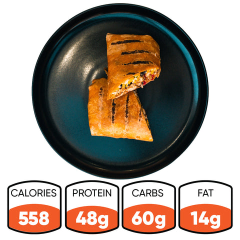 The Hey Arnold Burrito Subscription, a high-protein chicken wrap with 558 calories, 48g protein, 60g carbs, and 14g fat, is sliced in half on a black plate—ideal as a satisfying post-workout meal.